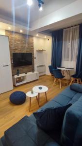 a living room with a blue couch and a flat screen tv at Studio Amore by Montebello in Zlatibor