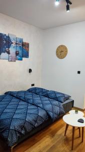 a bedroom with a bed and a clock on the wall at Studio Amore by Montebello in Zlatibor