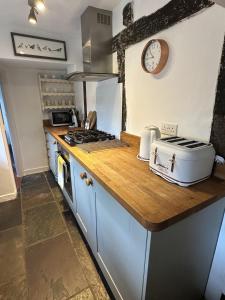 a kitchen with a counter top with a stove top oven at Eglantine in Crondall