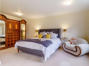 a bedroom with a large bed and a chair at 3 Bed in Thetford 83020 