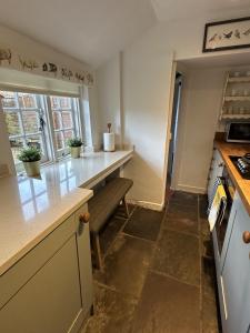 a kitchen with a counter and a bench in it at Eglantine in Crondall