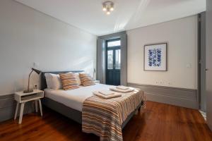 a bedroom with a bed with pillows on it at Cedofeita's Blue House in Porto