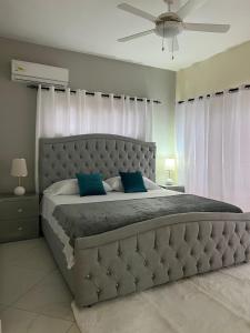 ein Schlafzimmer mit einem großen Bett mit blauen Kissen in der Unterkunft Villa encuentro sosua cabarrete in Sosúa