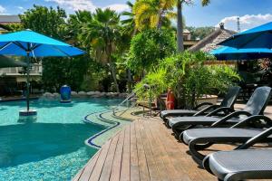 道格拉斯港Escape for Two - A Boutique Tropical Treasure的游泳池里一排带遮阳伞的躺椅