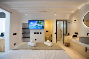 a bedroom with a bed and a sink and a tv at My Comfy Manto Town Apartment in Mikonos