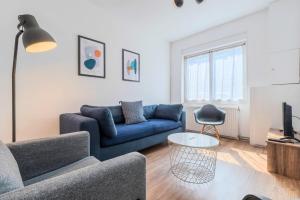 sala de estar con sofá azul y mesa en Roubaix - Beautiful 4 bedrooms house with terrace!, en Roubaix