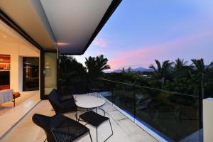 a balcony with a table and chairs and a view at 61 Murphy Street - Luxury Holiday Home in Port Douglas