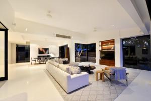 a living room with a couch and a table at 61 Murphy Street - Luxury Holiday Home in Port Douglas