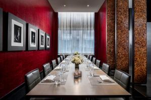 un comedor largo con una mesa larga y sillas en The Hazelton Hotel, en Toronto