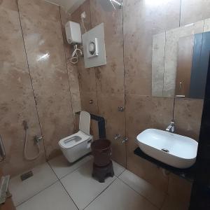 a bathroom with a toilet and a sink at Hotel Purushottam in Dwarka