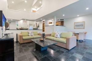 uma sala de estar com dois sofás e uma mesa em Tropical Resort-style Living on Mirage Golf Course em Port Douglas