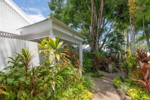 Biały dom z mnóstwem roślin i drzew w obiekcie Tropical Resort-style Living on Mirage Golf Course w mieście Port Douglas