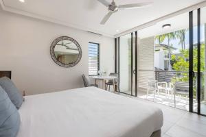 a bedroom with a white bed and a balcony at The Oasis at Temple - A Rooftop Resort Retreat in Port Douglas +17 photos