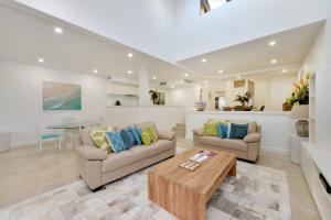 a living room with two couches and a table at Fairway Vistas - A Group Escape at Mirage Resort in Port Douglas