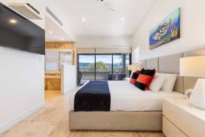Un dormitorio con una cama grande y una ventana grande. en Villa Mercedes - Poolside Tranquility on Murphy St, en Port Douglas