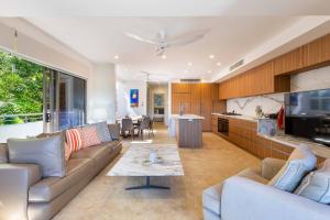 una sala de estar con un sofá y una mesa en Villa Mercedes - Poolside Tranquility on Murphy St, en Port Douglas