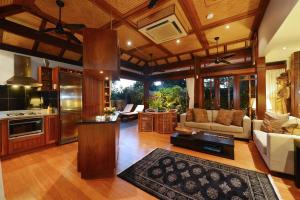 a kitchen and living room with a couch and a table at Paradiso Pavilion - An Intimate Bali-style Haven in Port Douglas