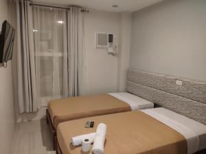 a hotel room with two beds and a television at D' Loft Iligan in Iligan