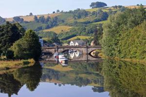 a bridge over a river with boats in the water at Lovely contemporary ground floor apartment. in Dean