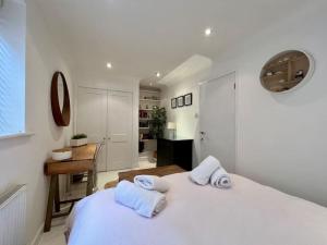 ein weißes Schlafzimmer mit einem Bett und einem Schreibtisch in der Unterkunft Ground floor central apartment in Kingsbridge