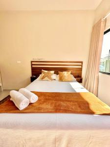 a bedroom with a bed with two towels on it at Pousada Villa Vantino in Penha