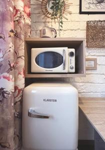eine Mikrowelle auf einem Kühlschrank in der Unterkunft Warszawa pokój For You in Warschau