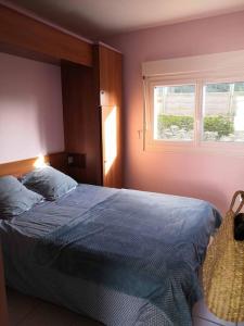 een slaapkamer met een blauw bed en een raam bij Appartement 27 Groix in La Bernerie-en-Retz