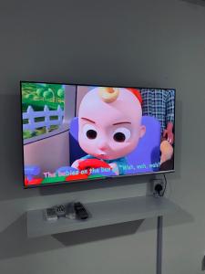 a flat screen tv with a cartoon girl on it at Comfy suites in Donggongon