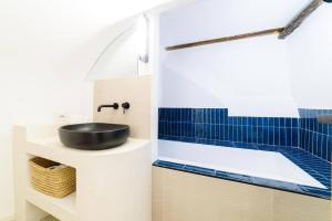 uma casa de banho com lavatório e azulejos azuis em [Napoli Chiaia] Wi-Fi & Netflix em Nápoles