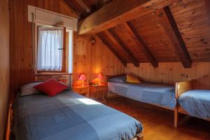 a bedroom with two beds in a wooden cabin at Casa Carlo in Colico
