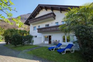 a house with two blue chairs in front of it at Casa Carlo in Colico