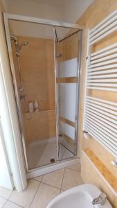 La salle de bains est pourvue d'une douche avec une porte en verre. dans l'établissement flat in Padova center, à Padoue