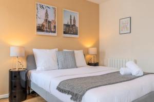 a bedroom with a large white bed with two lamps at Lille Hypercentre equipped studio for 2 people! in Lille