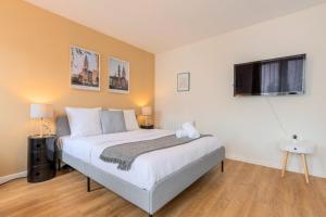 a bedroom with a large bed and a television at Lille Hypercentre equipped studio for 2 people! in Lille