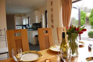 een tafel met een fles wijn en een vaas met bloemen bij Ty Pen y Bryn in Dolgellau in Dolgellau