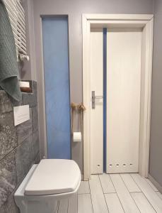ein Badezimmer mit einem WC und einer Glastür in der Unterkunft Warszawa pokój For You in Warschau