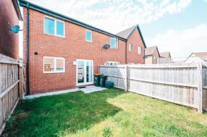 a brick house with a fence and a yard at Templer Mill by Solace Stays 2 Shower Rooms in Newport