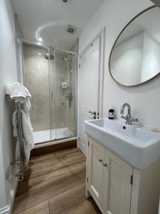 a white bathroom with a sink and a shower at The White House at The Tinners Arms in St Ives