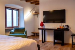 Schlafzimmer mit einem Bett, einem Schreibtisch und einem TV in der Unterkunft Relais Villa Carrara in Villa di Serio