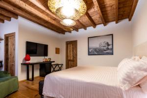 1 dormitorio con cama, escritorio y lámpara de araña en Relais Villa Carrara, en Villa di Serio