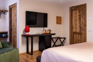 Zimmer mit einem Bett und einem Schreibtisch mit einem TV in der Unterkunft Relais Villa Carrara in Villa di Serio