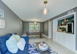 a living room with a blue couch and a tv at Grand 3 BD 2 BA House With Pool in Jacksonville Beach