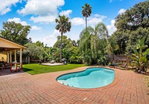 a swimming pool in a yard with a brick patio at Grand 3 BD 2 BA House With Pool in Jacksonville Beach