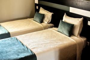 duas camas sentadas uma ao lado da outra num quarto em Residencial Portas do Sol em Valença