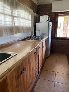 eine Küche mit einer Arbeitsplatte mit einem Kühlschrank und einer Spüle in der Unterkunft Casa GaloTabuas in Los Cocos