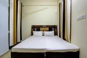 łóżko z białą pościelą i poduszkami w pokoju w obiekcie OYO The Dream Restaurant & Cafe w mieście Nārnaul