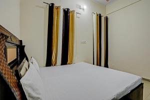 łóżko w pokoju z żółtymi zasłonami w obiekcie OYO The Dream Restaurant & Cafe w mieście Nārnaul