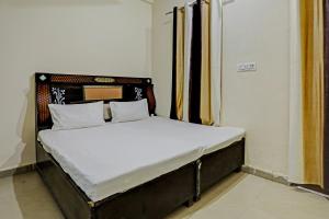 łóżko z białą pościelą i poduszkami w pokoju w obiekcie OYO The Dream Restaurant & Cafe w mieście Nārnaul