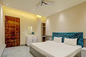 a bedroom with a large bed with a blue headboard at OYO Miraas Hotel And Banquet Hall in Ludhiana