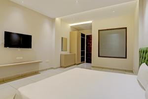 a bedroom with a large bed and a flat screen tv at OYO Miraas Hotel And Banquet Hall in Ludhiana